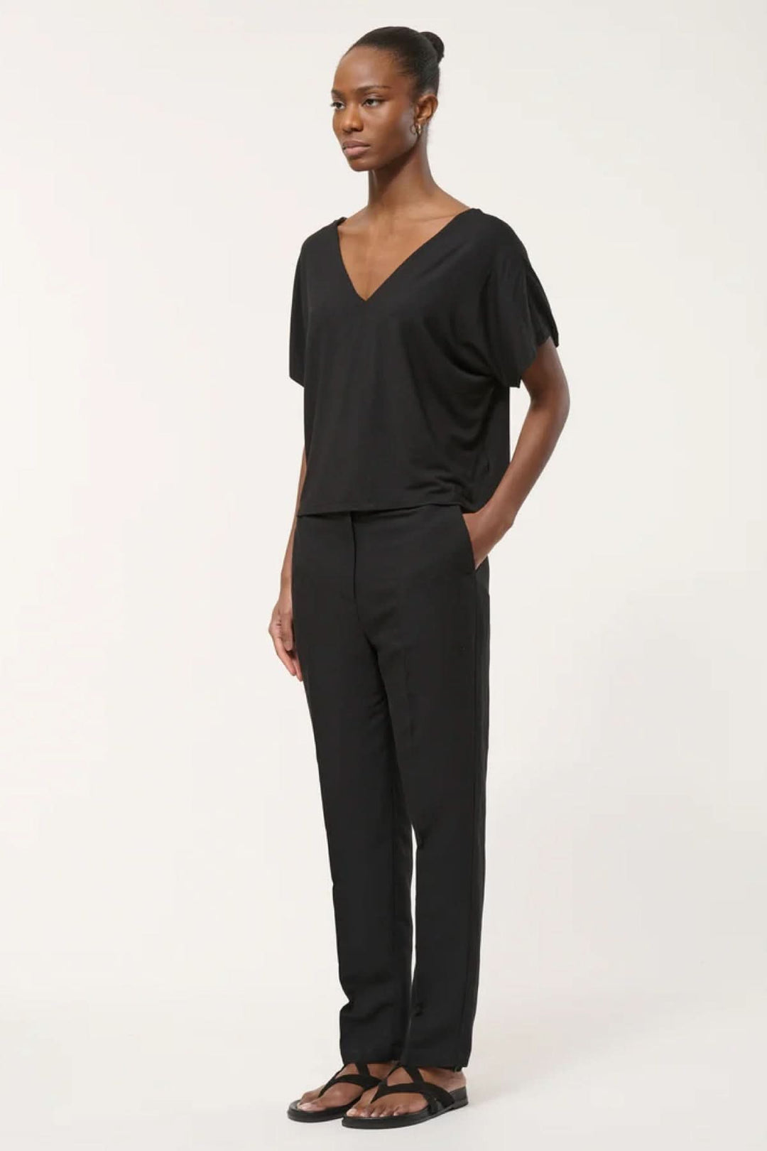 Pantalon tailleur coupe droite noir porté par une femme, idéal pour un look soigné au bureau ou en soirée, tissu fluide et élégant.