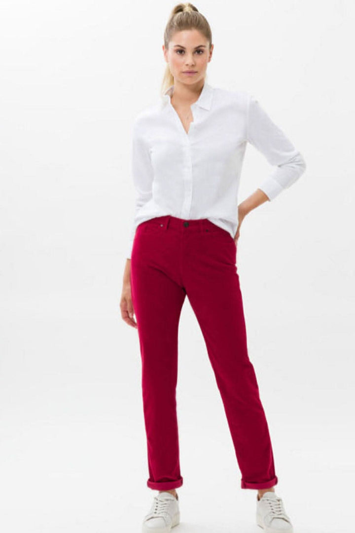 Femme portant un pantalon velouté MARY rouge avec chemise blanche, style classique et coupe droite.