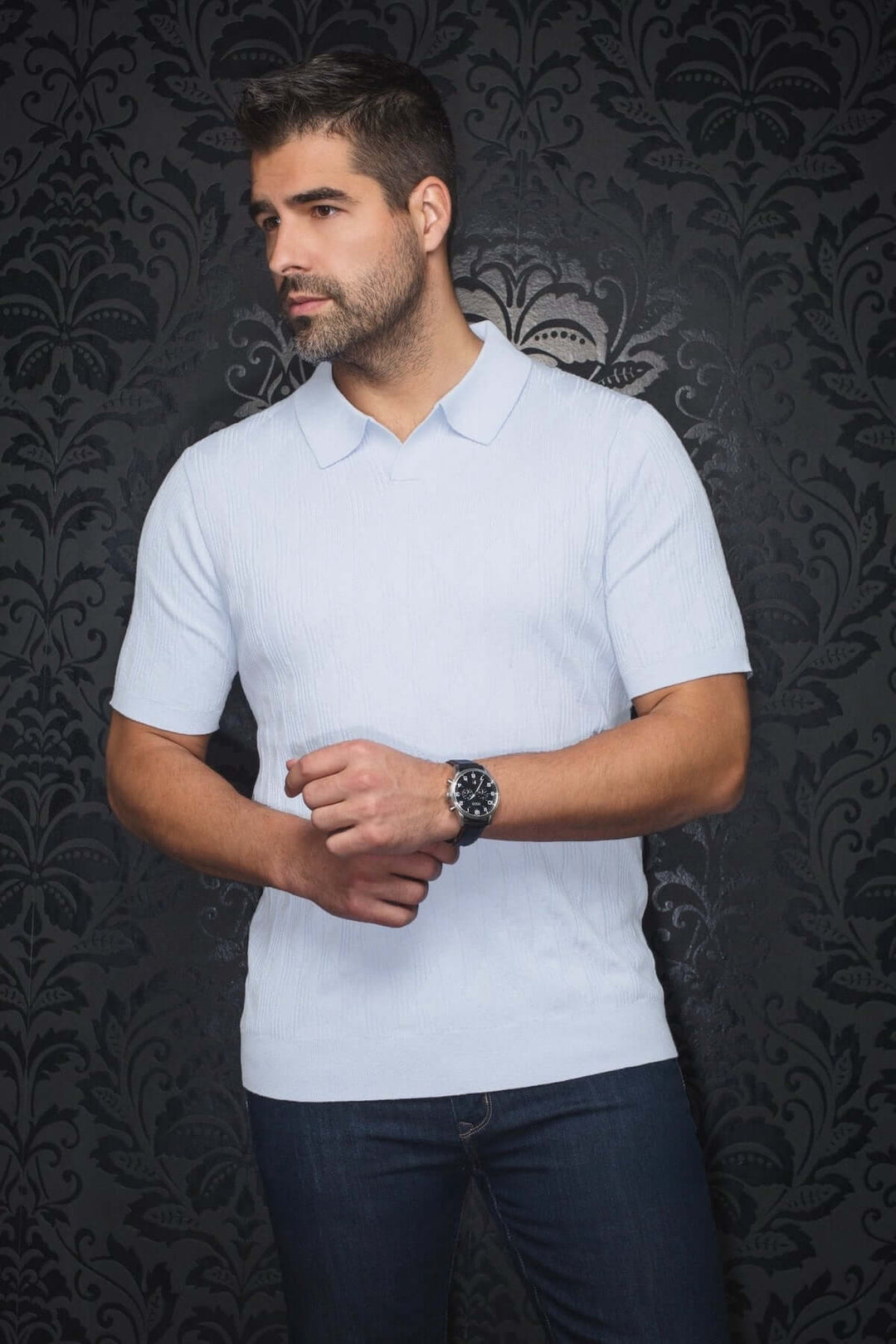 Homme portant un polo Lowick en maille fine, élégant et confortable, avec col ouvert, manches courtes et jeans.