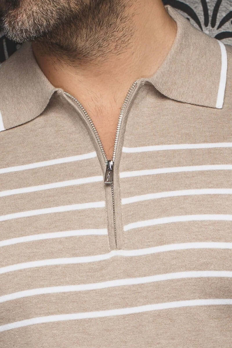 Polo Oban beige avec rayures blanches et col zippé, parfait pour un look élégant et décontracté.