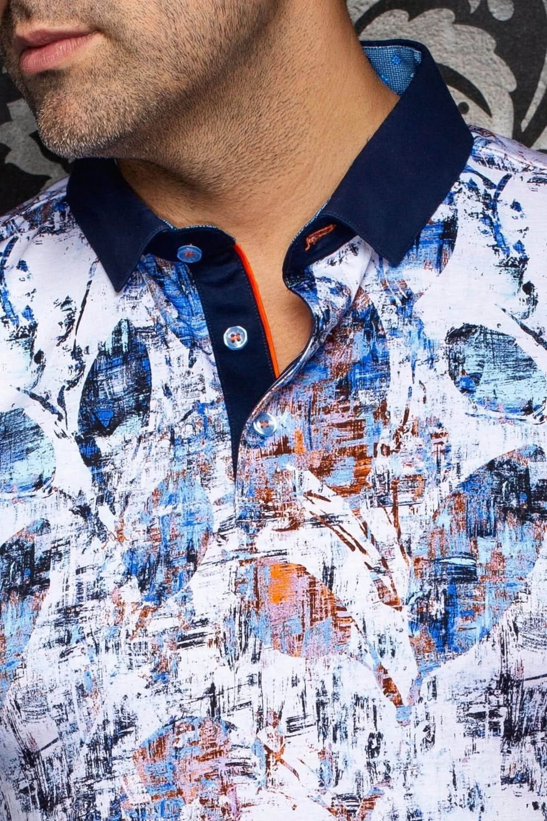 Homme portant un Polo YUCATAN avec imprimé artistique audacieux et col contrastant, parfait pour un look moderne et élégant.