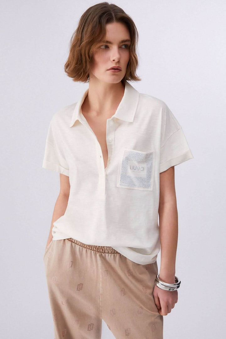 Polo à manches courtes avec poche décorative porté par un mannequin, affichant un style décontracté et contemporain.