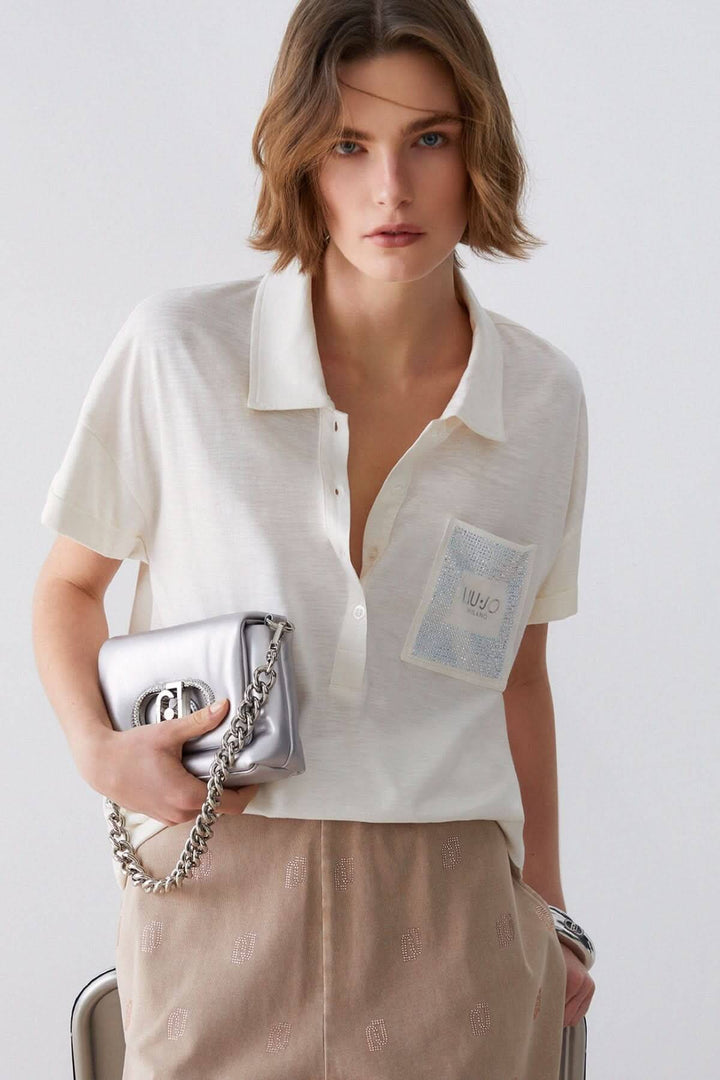 Femme portant un Polo à manches courtes avec poche décorative, tenue élégante et décontractée.