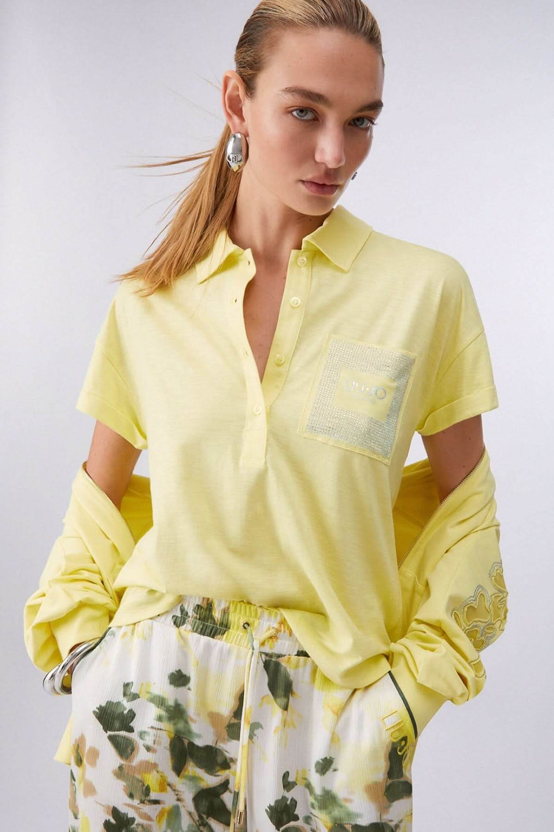 Polo à manches courtes avec poche décorative en jaune porté par un modèle, affichant un look décontracté idéal pour le quotidien.