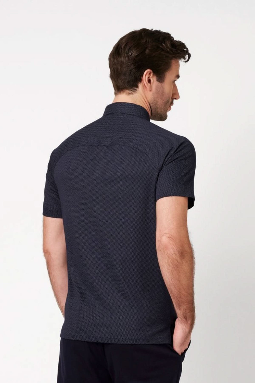 Homme portant un Polo à manches courtes micro-texturé de dos, affichant une coupe ajustée et un design élégant.