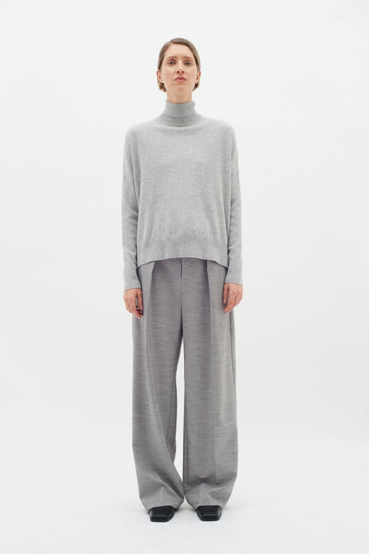 Pull à col roulé Kellsie en maille douce, associé à un pantalon large, look élégant et confortable.