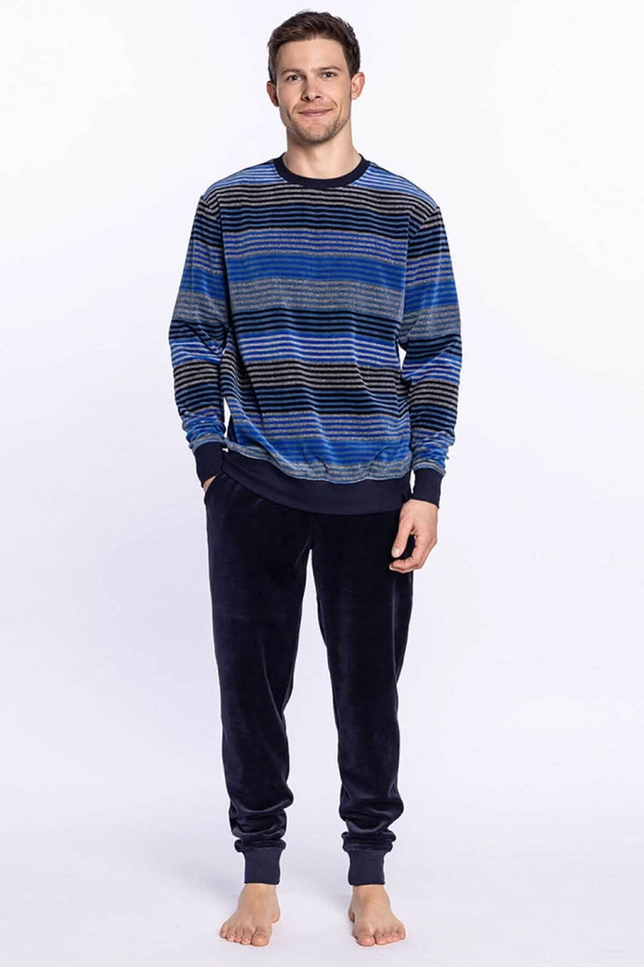 Homme portant un pyjama long en velours, tee-shirt rayé bleu et pantalon uni, idéal pour l&