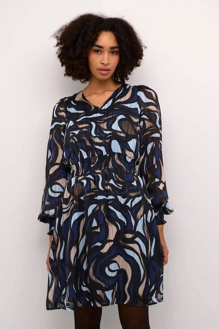 Robe Margo fluide avec manches longues, col en V et motif abstrait bleu, noir et beige.