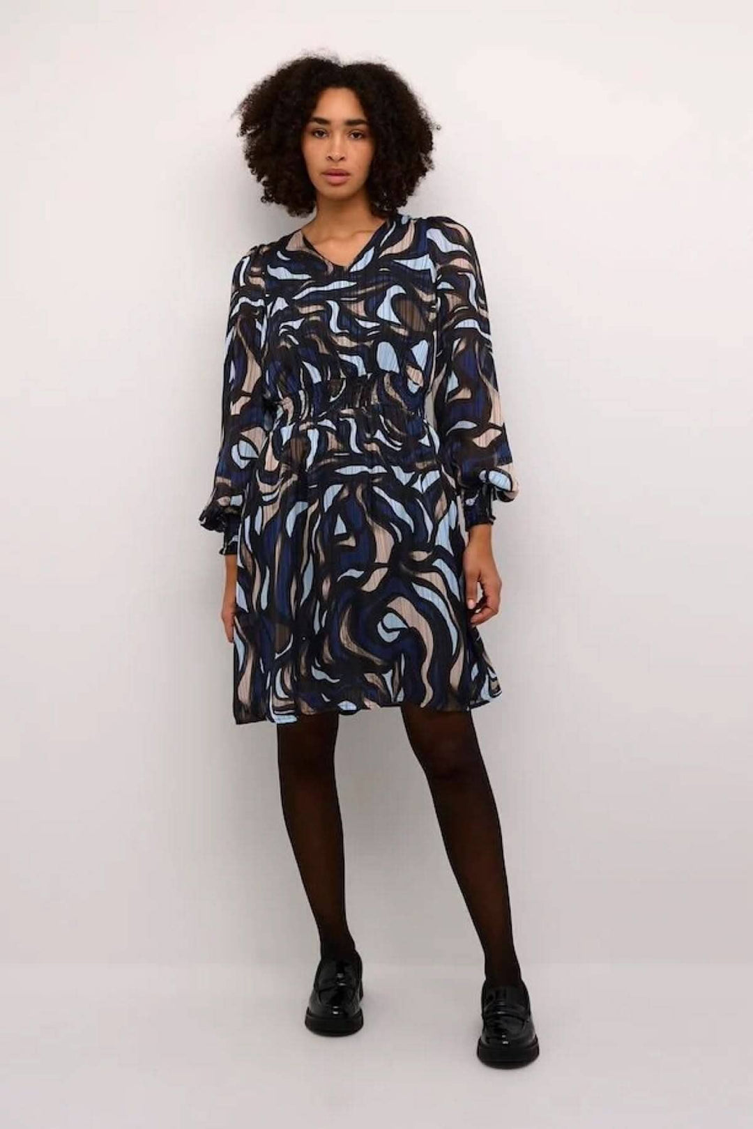 Robe Margo à silhouette fluide, manches longues, col en V, avec motif abstrait bleu, noir et beige.