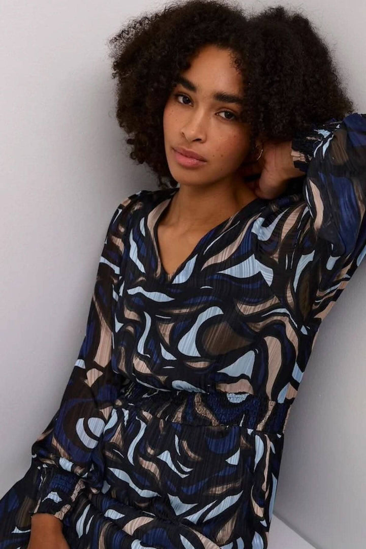 Robe Margo à manches longues avec motif abstrait en bleu, noir et beige, col en V et silhouette fluide.