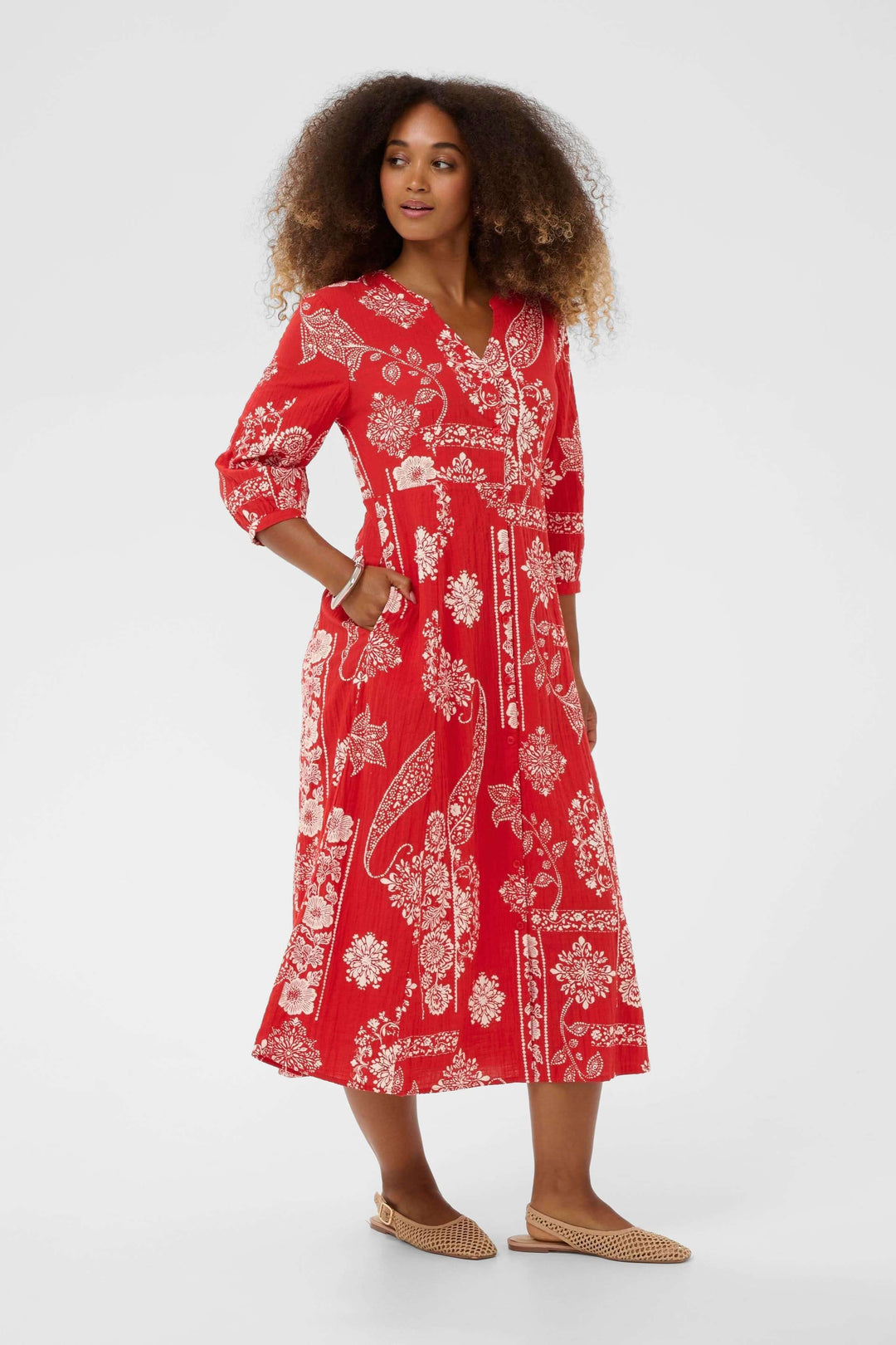 Robe Bia midi imprimée à manches trois-quarts en rouge avec imprimé décoratif et coupe fluide élégante, modèle portant des chaussures plates.