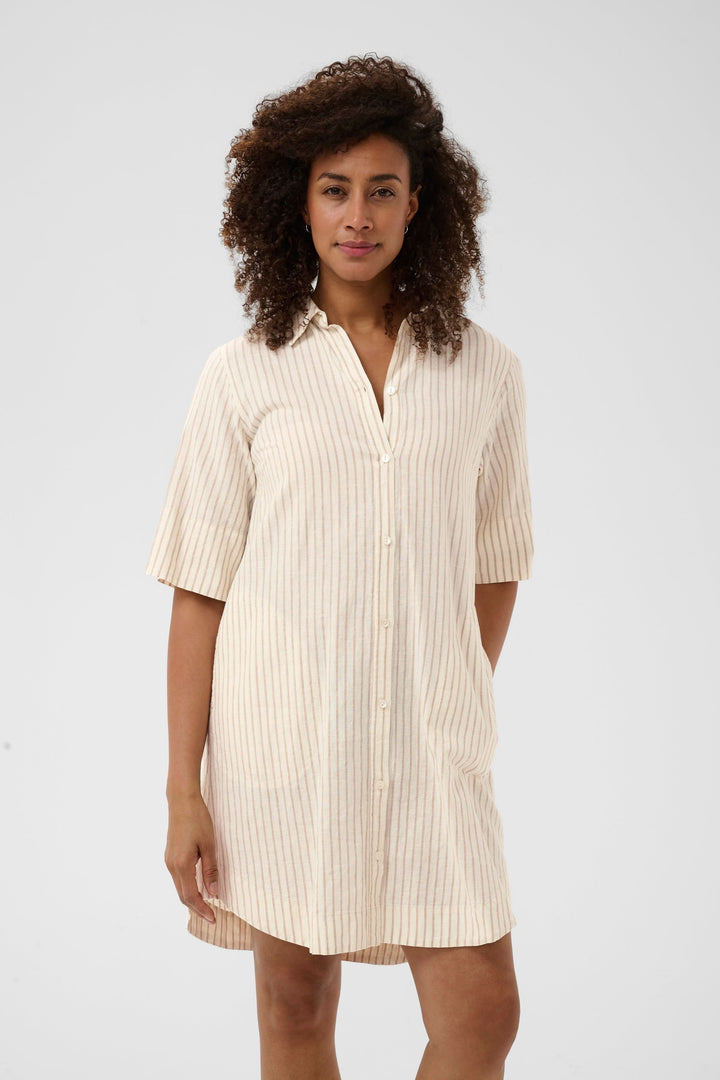 Femme portant une robe chemise Berrit fluide à manches courtes, idéale pour un style décontracté et élégant.