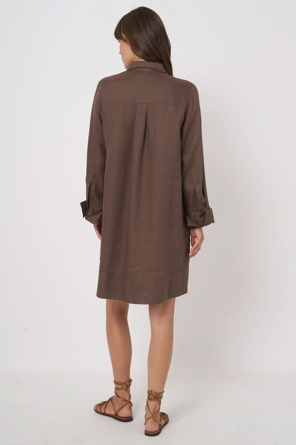 Vue arrière de la robe chemise à manches longues en tissu marron, mettant en valeur sa coupe fluide et décontractée.