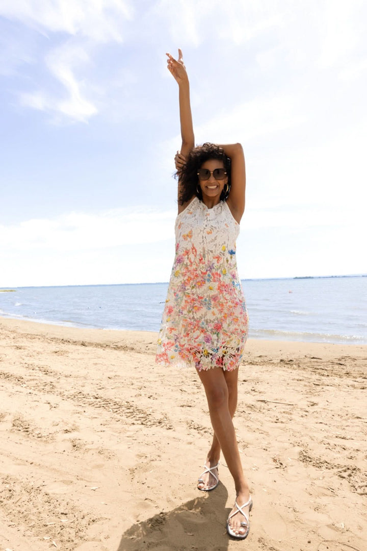 Femme portant une robe florale avec détails sur la plage, robe en dentelle, été