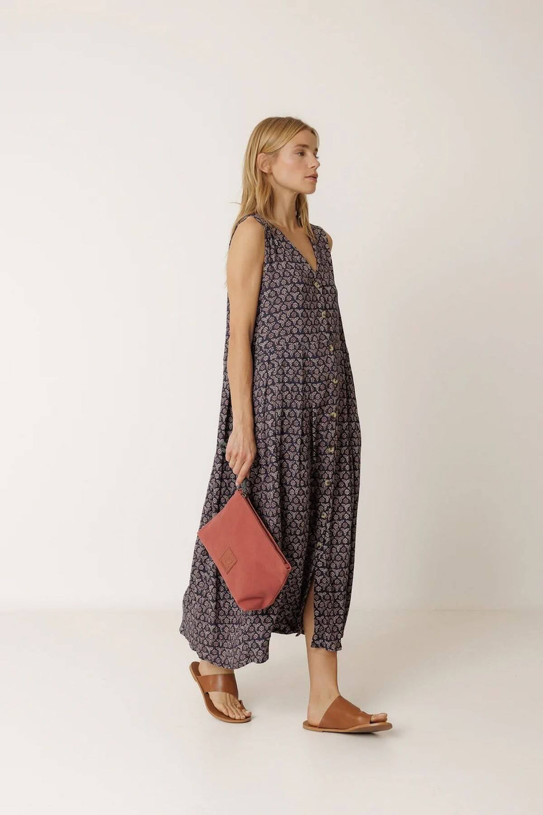 Femme portant une robe longue réversible à imprimé, tenue fluide et sans manches, avec un sac rose, confort d&