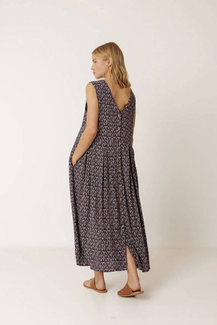 Femme portant une robe longue réversible à imprimé, design polyvalent et fluide, idéale pour le quotidien ou les escapades estivales.