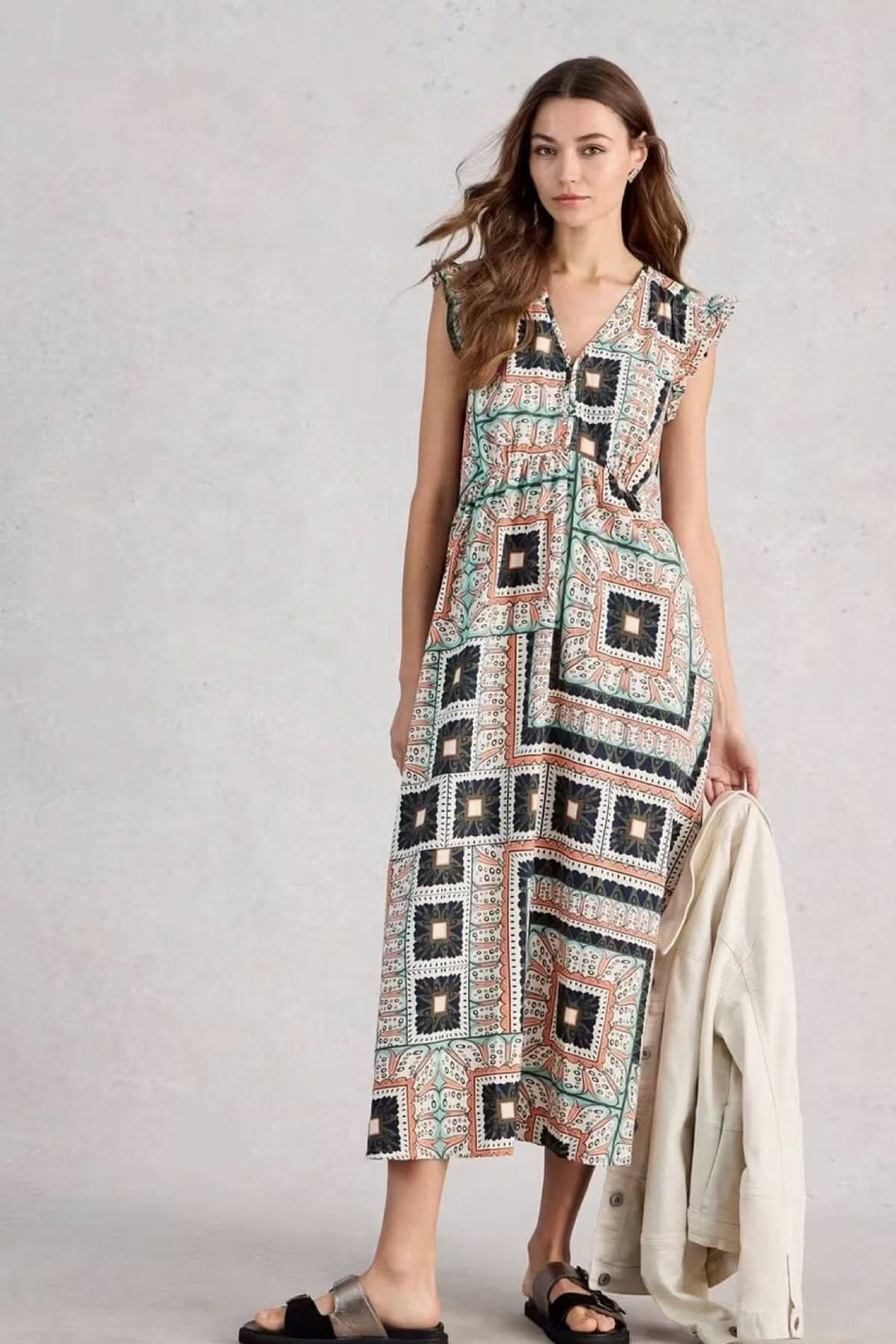 Robe longue sans manches Lorna en lin mélangé, coupe évasée fluide et imprimé graphique, portée par une femme avec sandales.