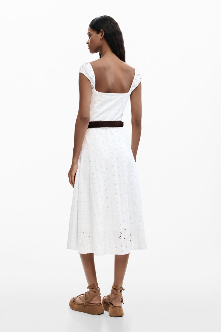 Femme portant une robe midi brodée en broderie anglaise, vue de dos, soulignant l&