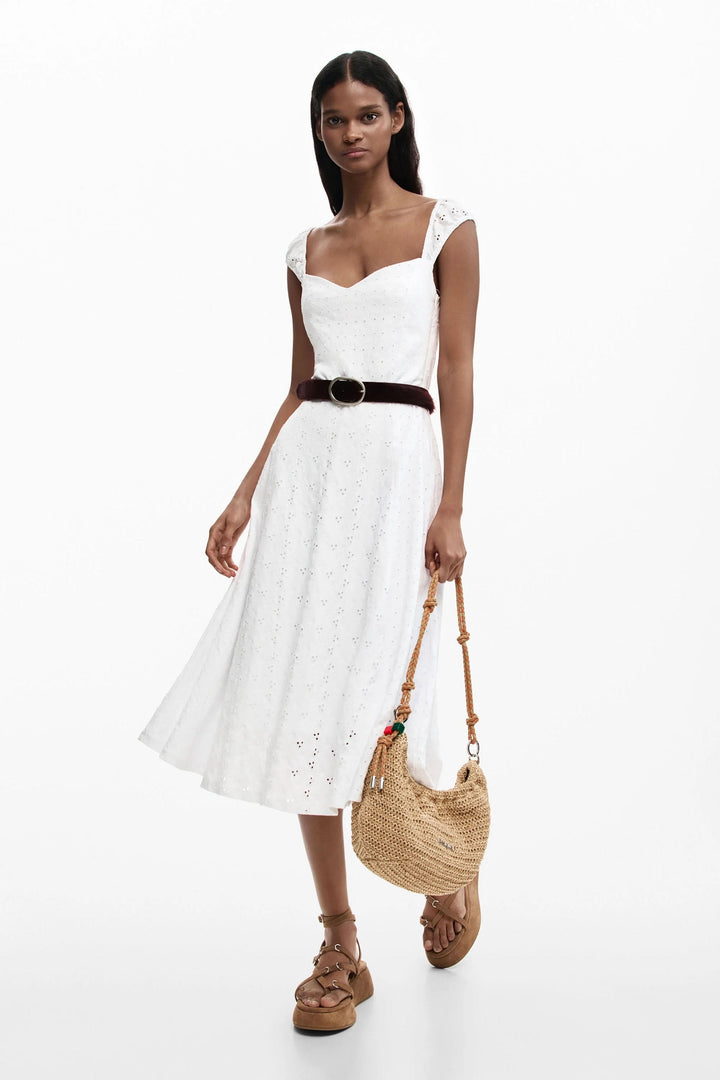 Robe midi brodée blanche avec broderie anglaise, encolure cœur, bretelles larges et jupe évasée, idéale pour un look estival élégant.