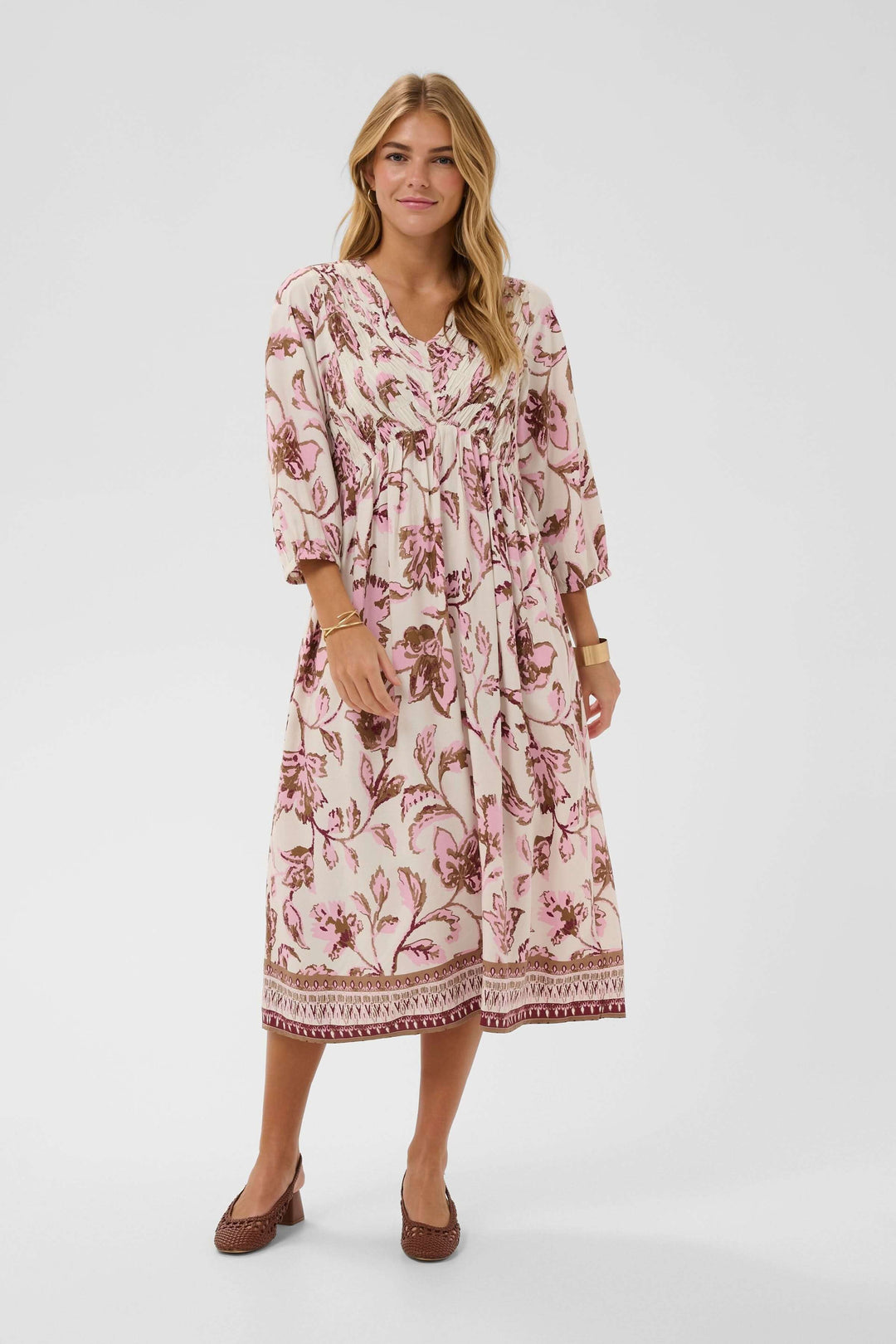 Robe midi fluide à imprimé floral avec encolure en V et manches trois-quarts, élégante et confortable pour un look quotidien raffiné.