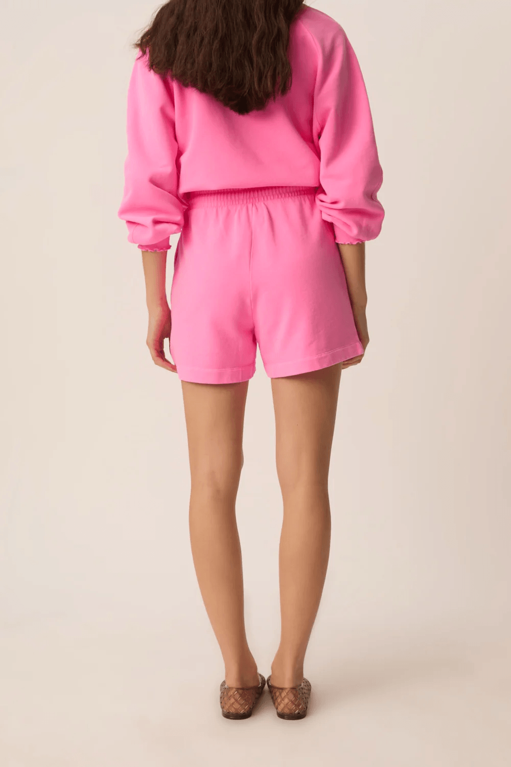 Femme portant le Short Yasti taille élastique à cordon coupe décontractée, vue arrière, confortable et casual en rose.