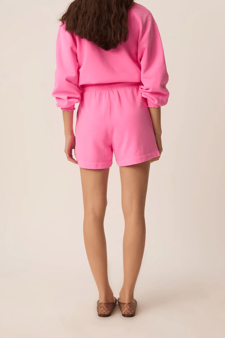 Femme portant le Short Yasti taille élastique à cordon coupe décontractée, vue arrière, confortable et casual en rose.