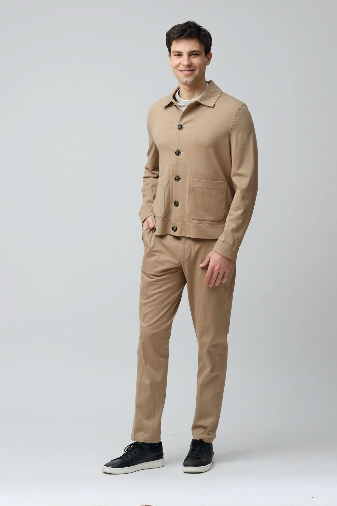 Homme portant une surchemise stretch beige avec pantalon assorti, look élégant et décontracté.