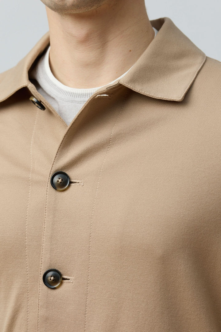 Surchemise stretch beige avec col structuré et boutons sur le devant pour un look moderne et polyvalent.
