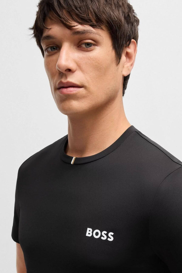 Homme portant un t-shirt BOSS épuré noir avec logo blanc et encolure contrastante.