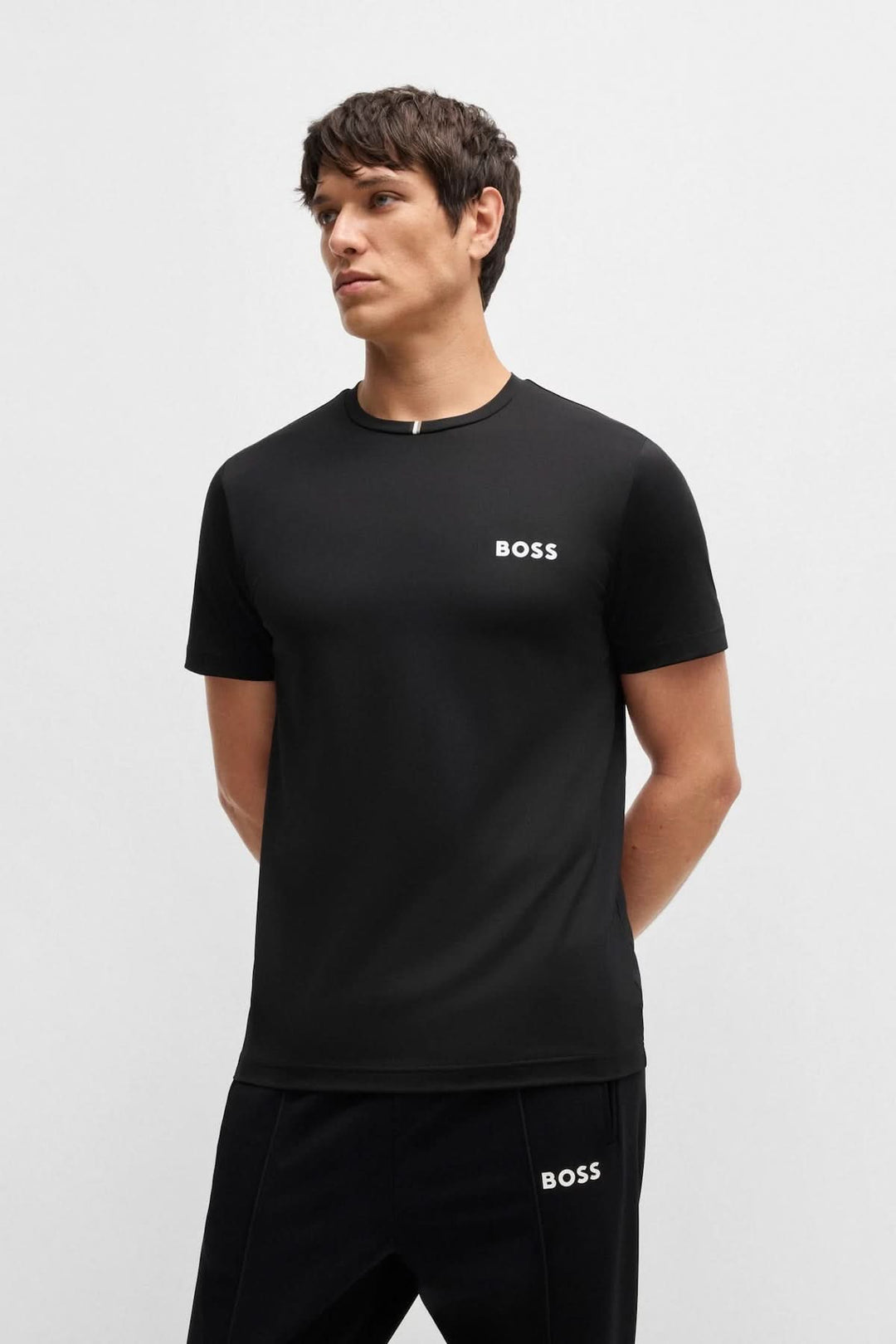 Homme portant un t-shirt BOSS noir avec logo discret, encolure ronde et coupe droite, parfait pour un look casual chic.