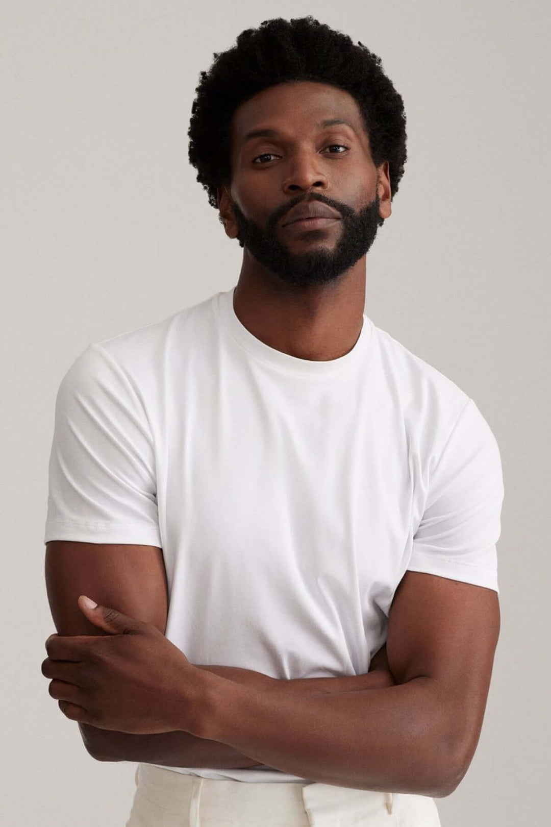 Homme portant un t-shirt blanc moderne, coupe décontractée et encolure ronde.