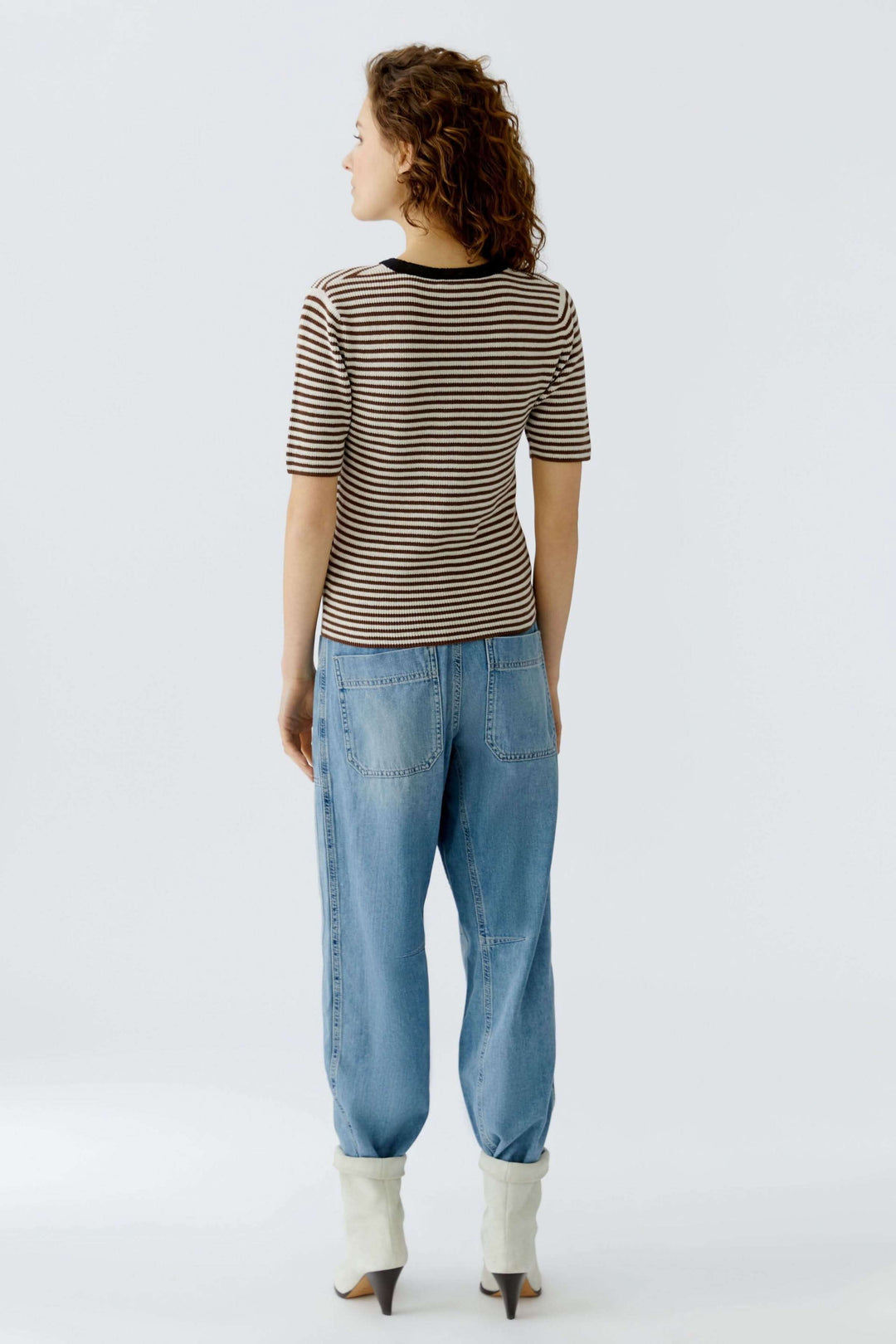 T-shirt élégant à rayures, coupe ajustée, encolure contrastante porté avec pantalon décontracté, vue de dos. Décris moi le produit en français.