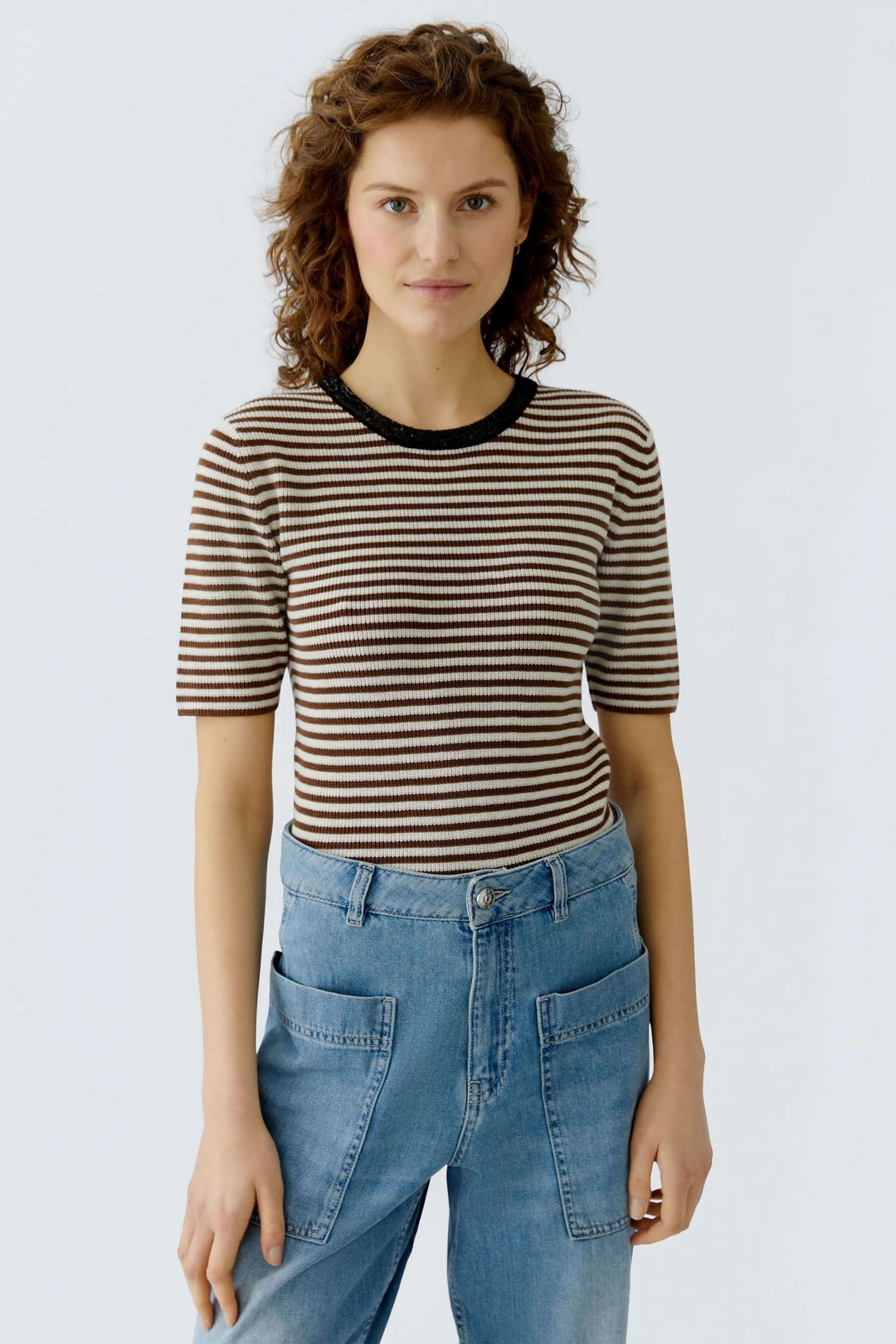 T-shirt rayé élégant et moderne avec encolure contrastante, coupe ajustée pour silhouette, porté avec un jean. Décris moi le produit en français.