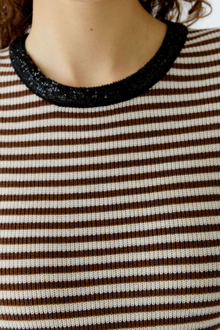 T-shirt à rayures avec encolure contrastante noire, coupe ajustée élégante. Décris moi le produit en français.