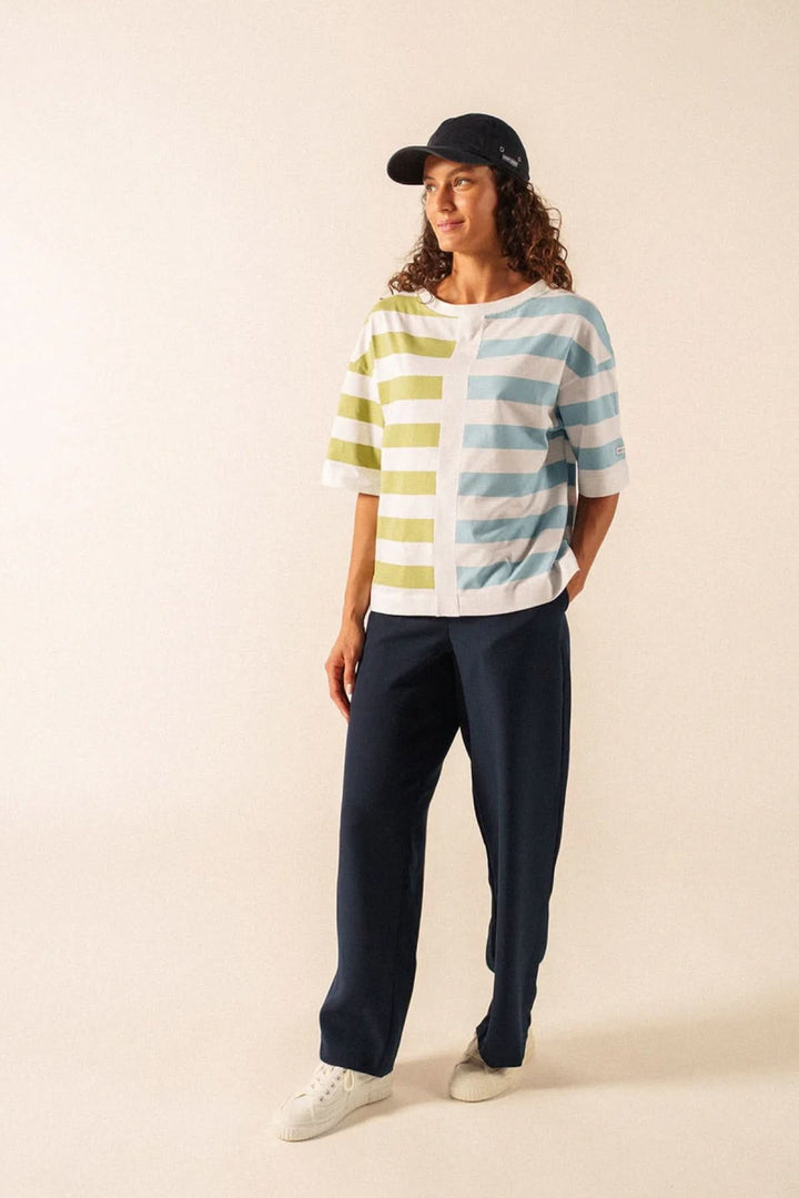 Femme portant le T-shirt Estelle avec motif graphique, manches courtes et coupe fluide, associé à un pantalon pour un look polyvalent.