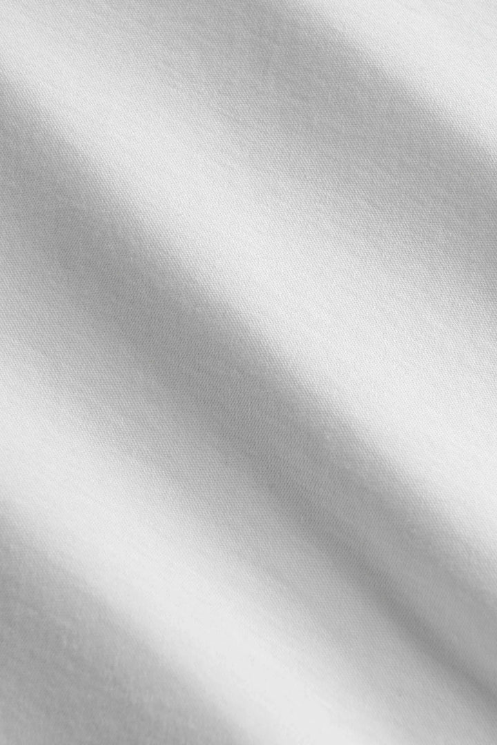 Détails d'un tissu lisse et technique en blanc, parfait pour un t-shirt minimaliste.