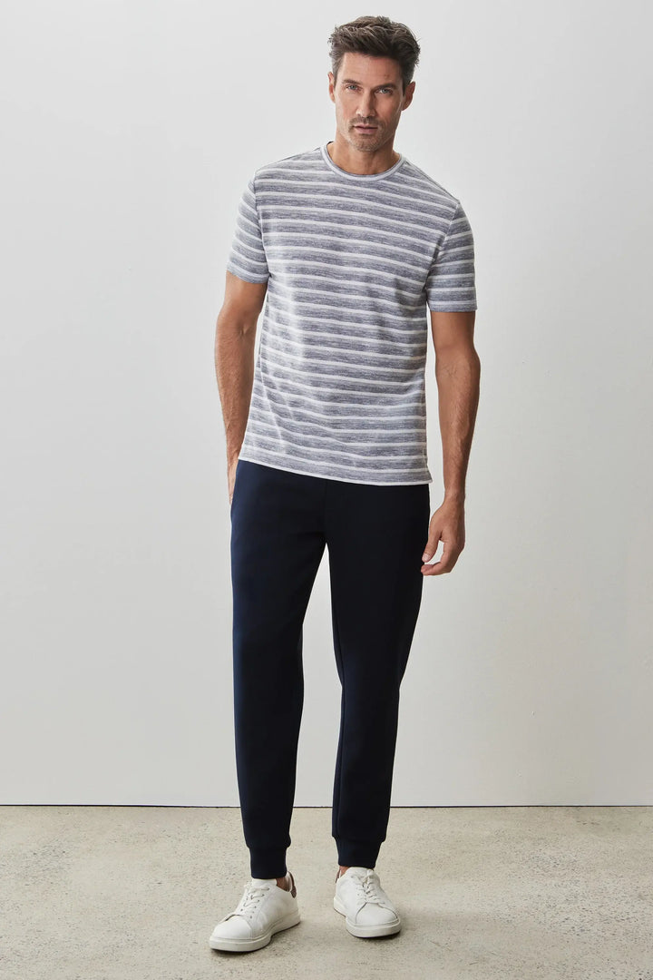 T-shirt Hockney à rayures texturées, coupe droite, associé à un pantalon sombre pour un look estival décontracté.