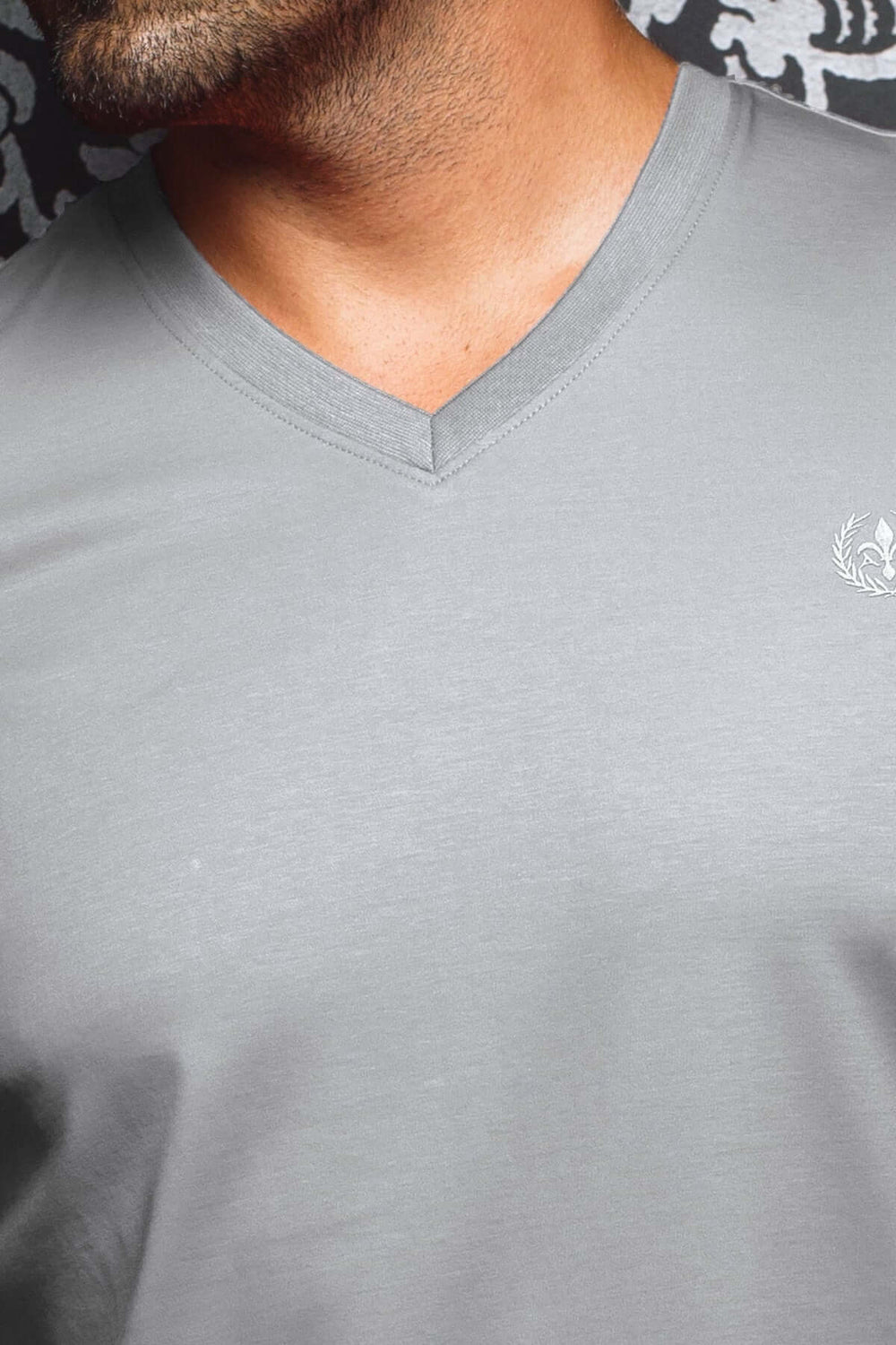 T-shirt gris élégant à col en V avec logo brodé, conçu pour confort et style décontracté.