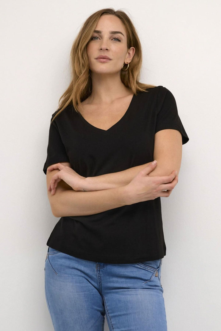 T-shirt Naia noir pour femme avec encolure en V et manches courtes, porté avec un jean.