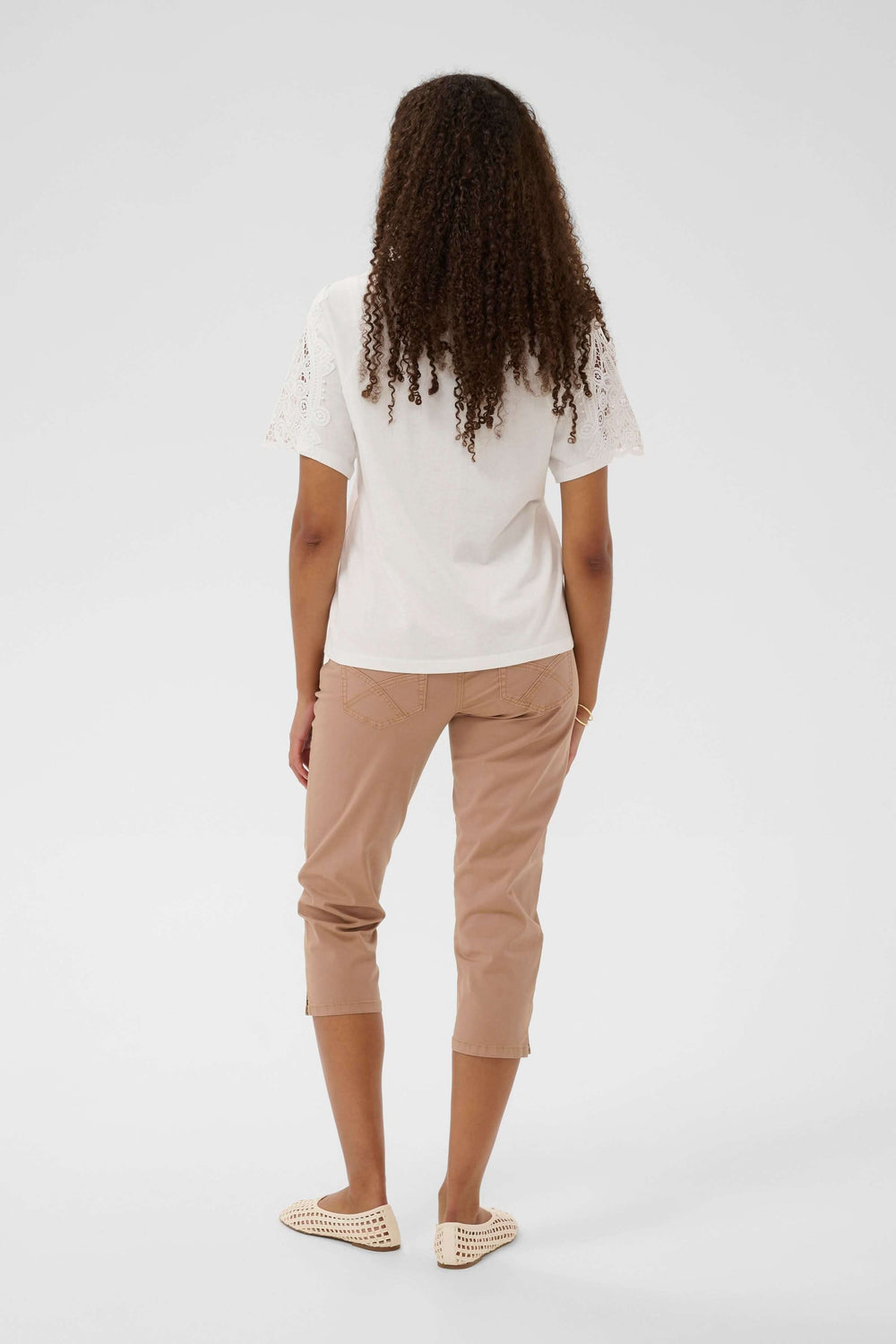 Vue arrière T-shirt Suny à manches courtes avec dentelle porté avec un pantalon beige