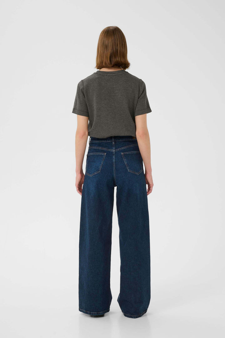 Femme de dos portant un t-shirt gris et un jean large, montrant un style décontracté et élégant.