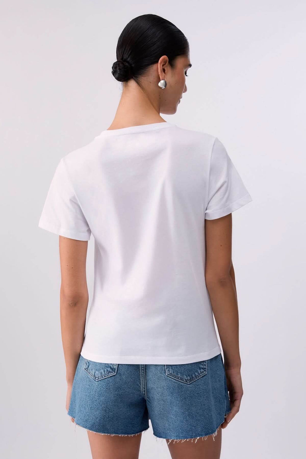 Vue arrière d'un T-shirt avec motif décoratif porté avec short en jean.