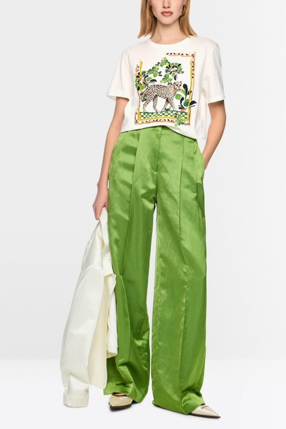 T-shirt avec motif léopard et perles brodées, porté avec pantalon vert ample.