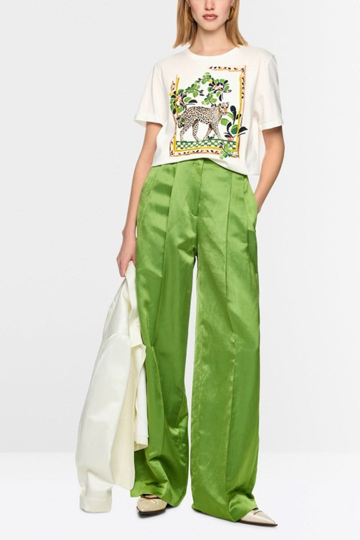 T-shirt avec motif léopard et perles brodées, porté avec pantalon vert ample.