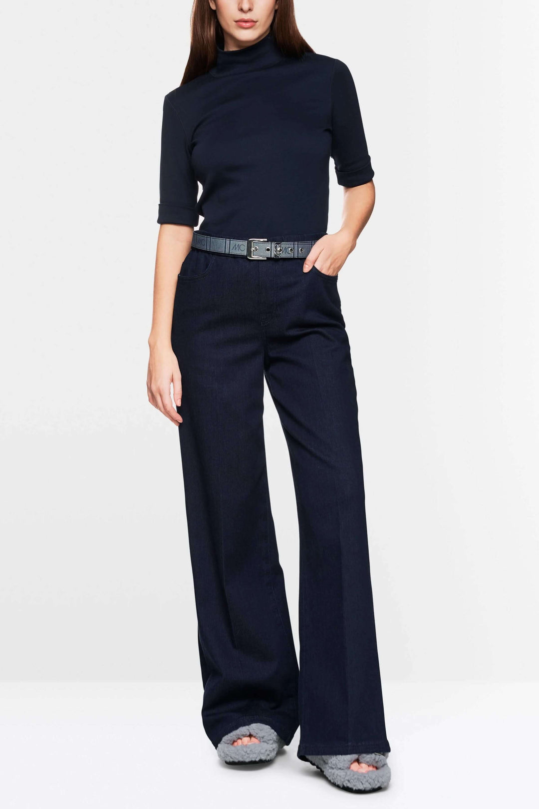 Modèle féminin portant un t-shirt basique à col montant et un pantalon large, style minimaliste et chic.