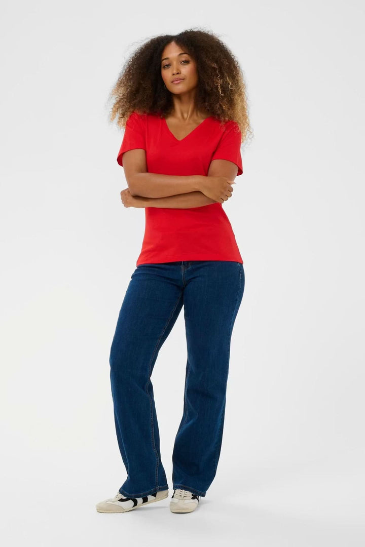 T-shirt col en V rouge porté par un mannequin, matière douce et extensible, coupe flatteuse et confortable pour usage quotidien.