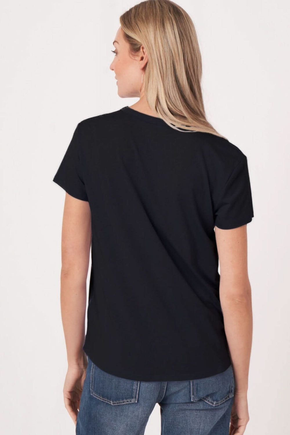 Femme portant un T-shirt col en V manches courtes noir, vue de dos, look décontracté et moderne.