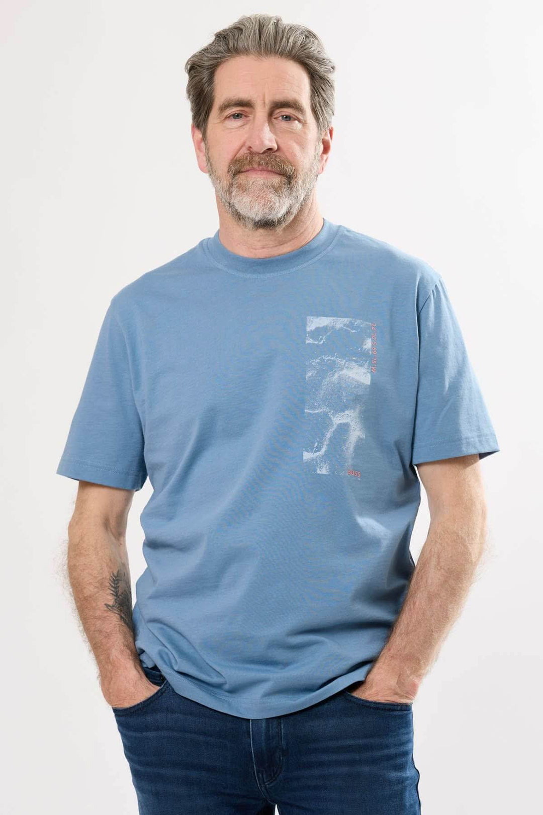 Homme portant un t-shirt col rond bleu, design contemporain, avec une coupe décontractée et des manches courtes.