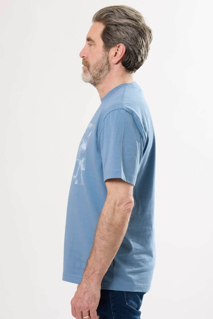 T-shirt col rond bleu en coton, porté de profil pour un look décontracté et élégant.