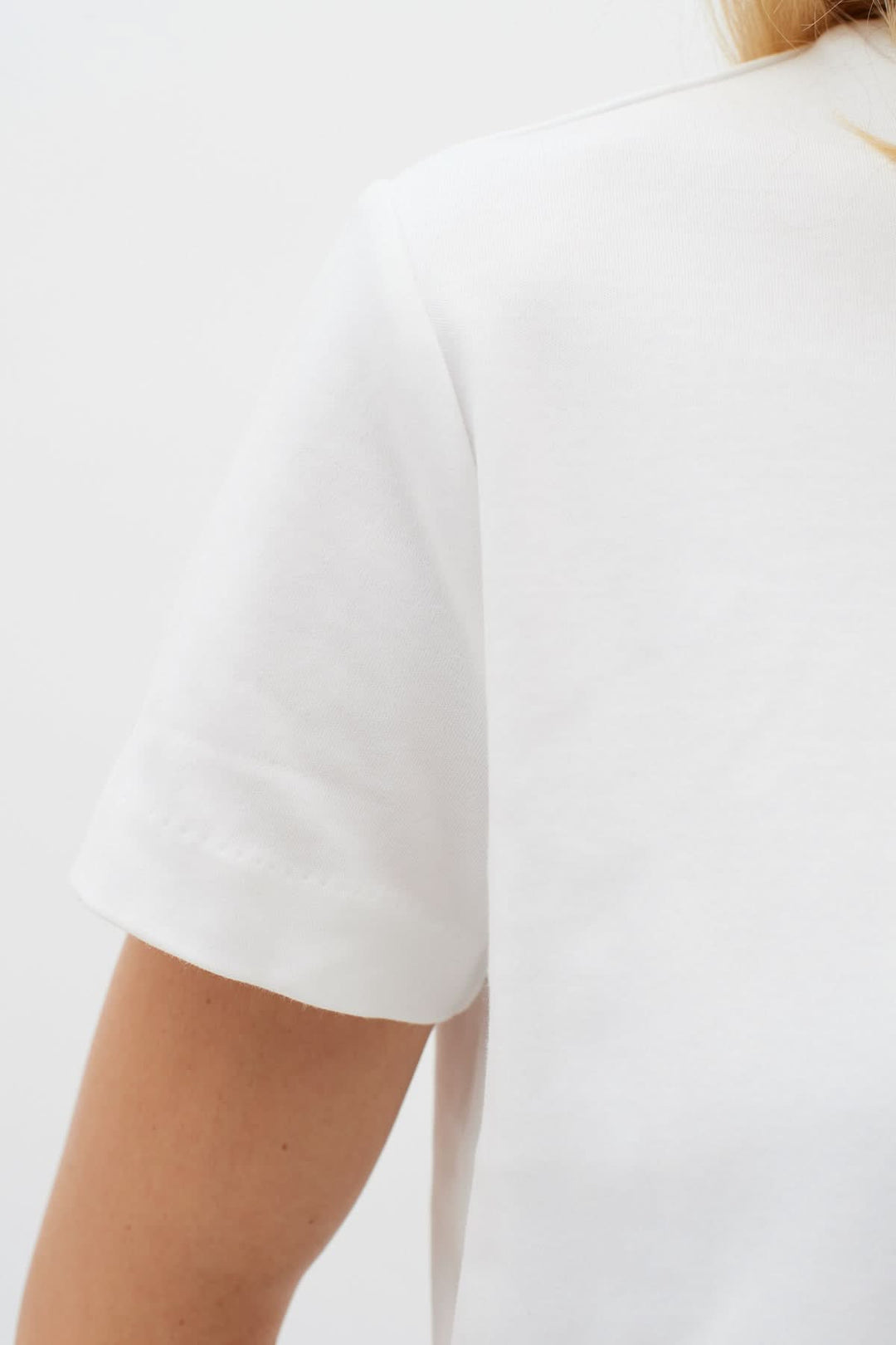 Détail arrière d'un T-shirt col rond Luke en coton blanc, montrant les manches et la texture douce.